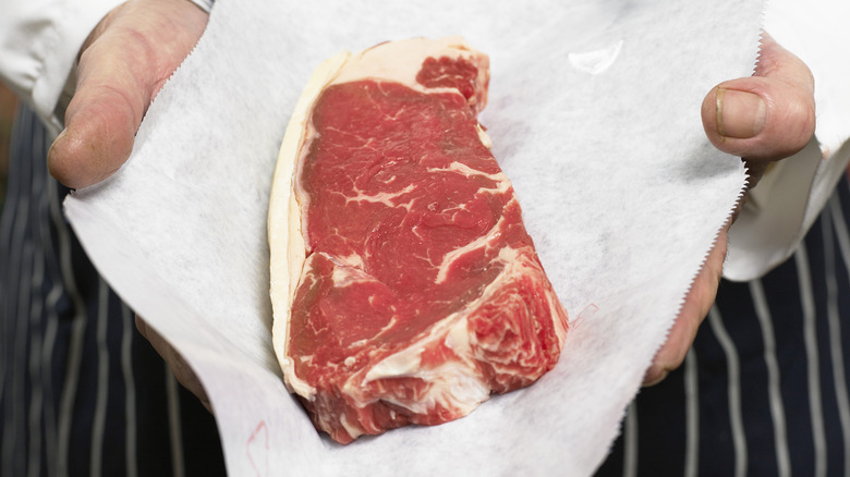 butcher holding steak