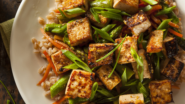 Stir-fried tofu and vegetables on white plate