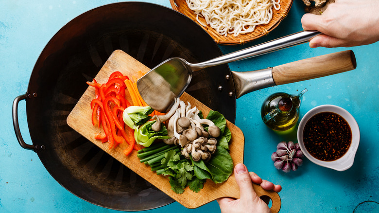 Stir-fry ingredients being added to a wok