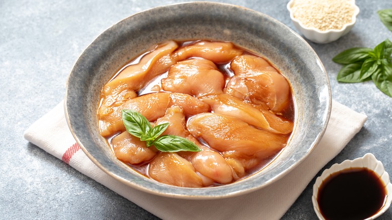 Chicken marinating in a bowl