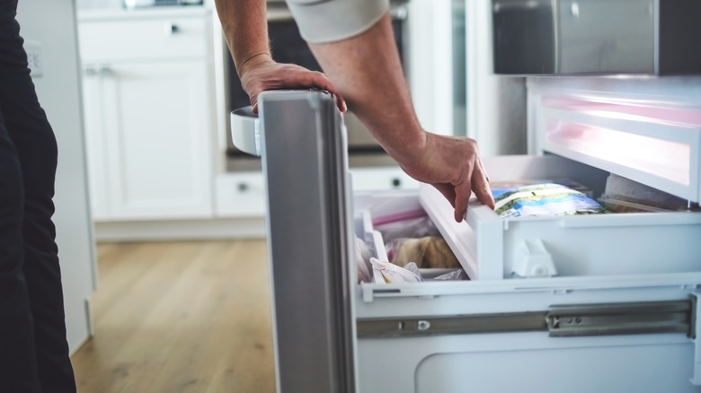 Man looking inside a freezer