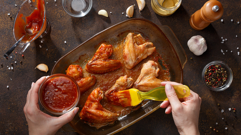 Brushing chicken wings with sauce