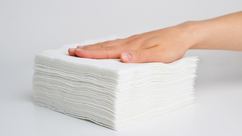 A woman's hand on a stack of napkins