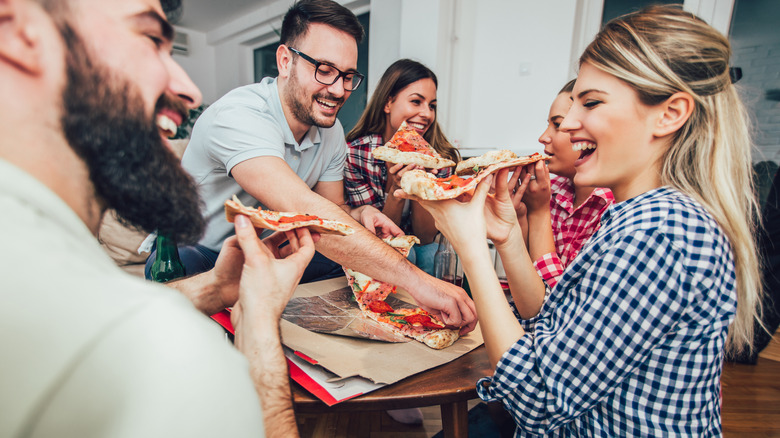 group of people eating pizza