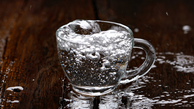 Tea cup overflowing with water