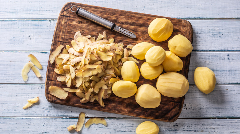 peeled potatoes on wooden cutting board