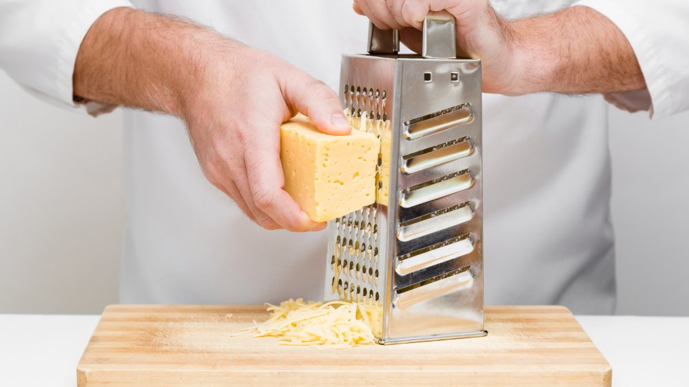 Chef's hands grating cheese