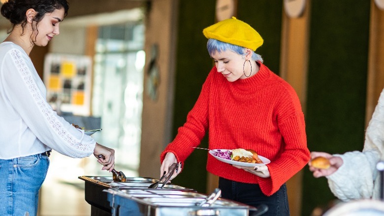 people taking food from chafing dishes