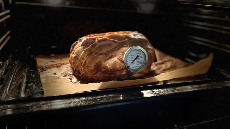 Beef Wellington in oven with a meat thermometer