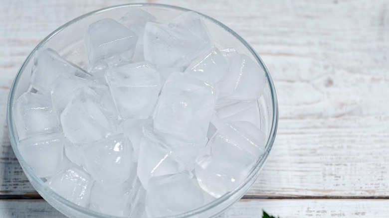 Bowl of ice cubes on a wooden counter