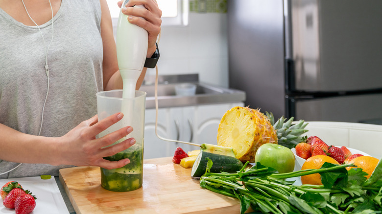 woman using immersion blender