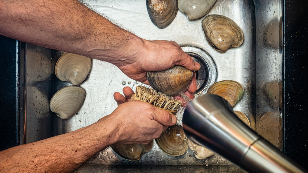 Man washing shellfish in sink