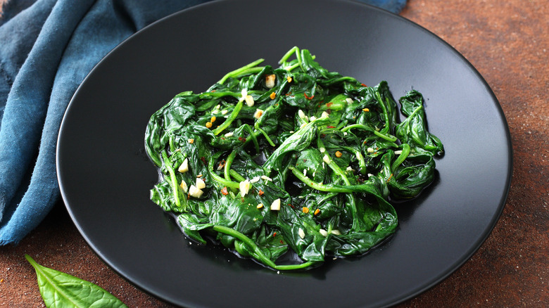 cooked spinach in black dish