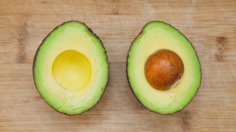 two avocado halves on table