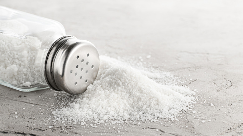 Salt shaker spilling salt grains