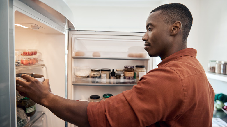 man pulling out leftovers