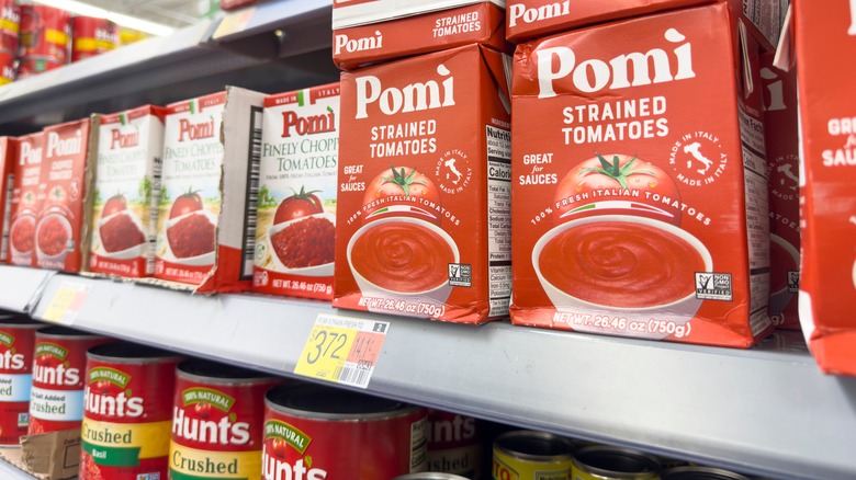 cans and cartons of tomatoes in grocery store