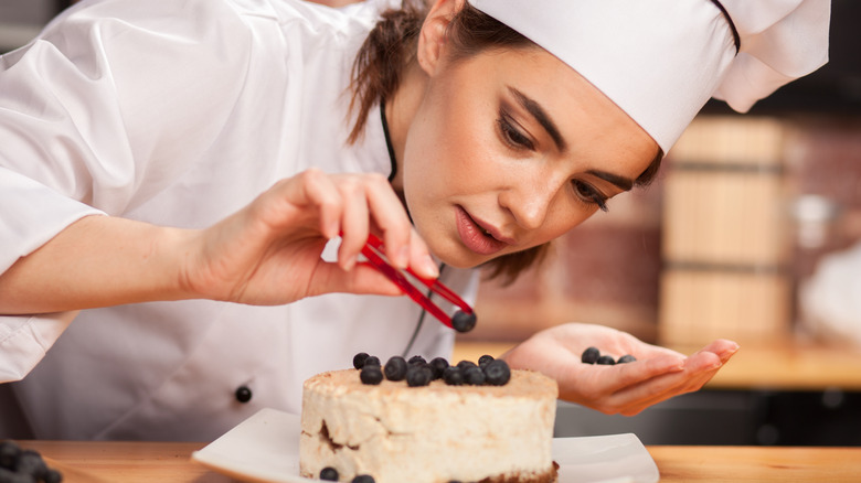 chef placing berries on cake