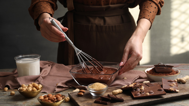 Person whisking ganache surrounded by other ingredients