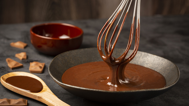 Whisk in bowl of chocolate ganache