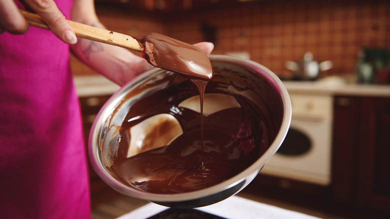 woman stirring melted chocolate ganache