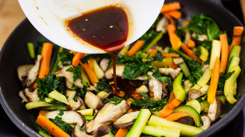 Pouring soy sauce onto vegetables