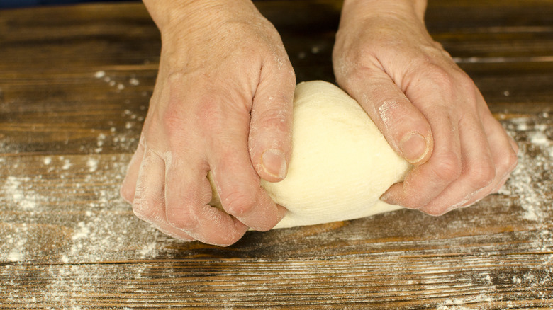 Hands kneading empanada dough