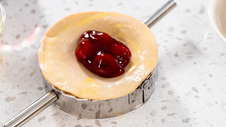 Cherry pie filling in raw empanada dough