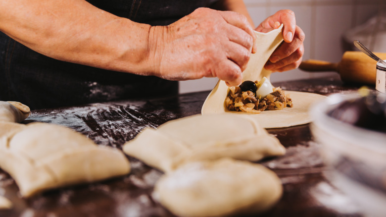 A person making empanadas