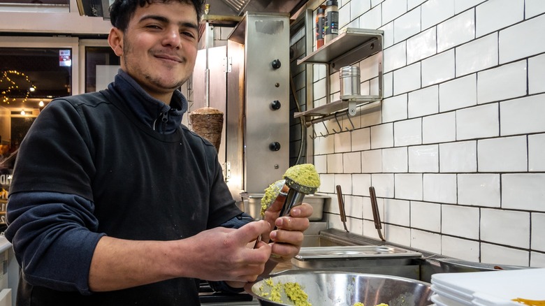 cook forming falafel balls using scoop