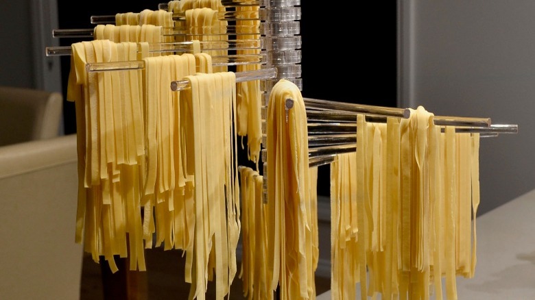 pasta strands drying on rack