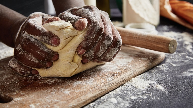 hands kneading dough on counter