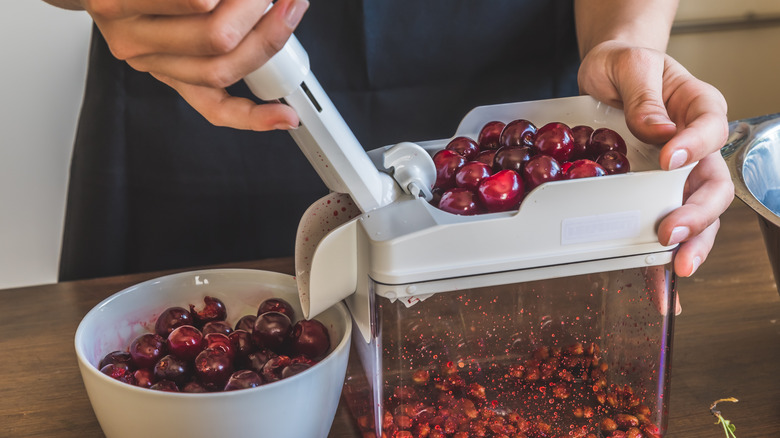 person using a cherry pitter