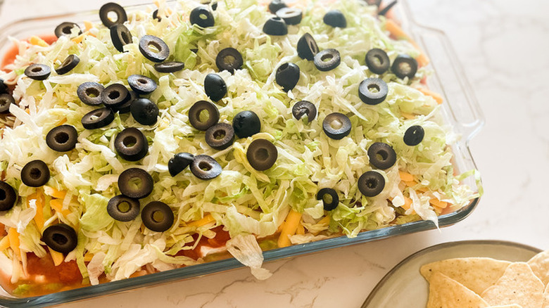 7-layer dip with olives, lettuce, and cheese