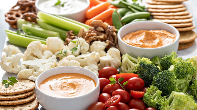 platter of dips and crudites with pretzels and crackers