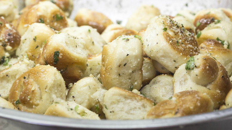 Garlic knots being tossed in garlic butter