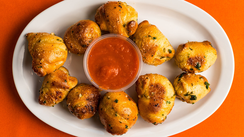 Garlic knots on a plate with marinara dipping sauce