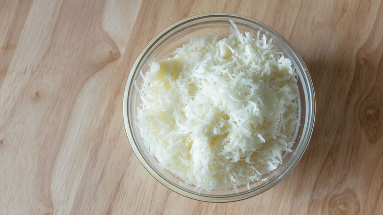 Grated pecorino Romano cheese in a glass bowl