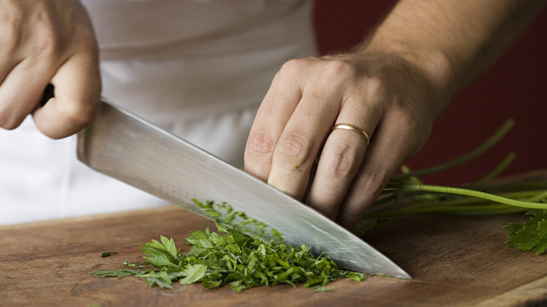 Hands chopping fresh parsley