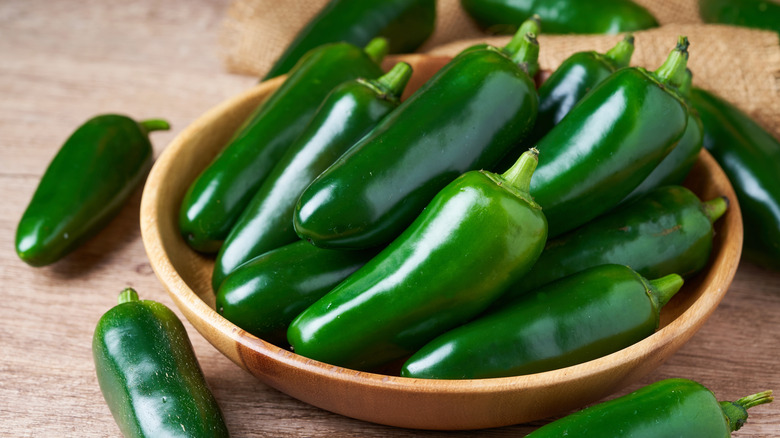 Green jalapeños in a wooden bowl