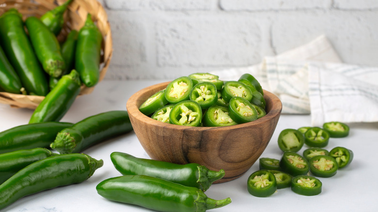 Jalapeños in wooden bowl sliced and whole