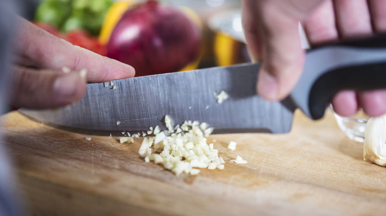 Hands chopping fresh garlic