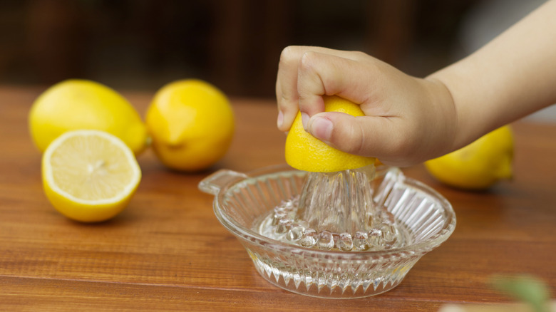 Lemon being juiced by hand