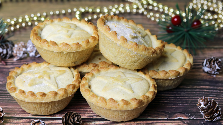 Stacked mince pies with decorative Christmas items