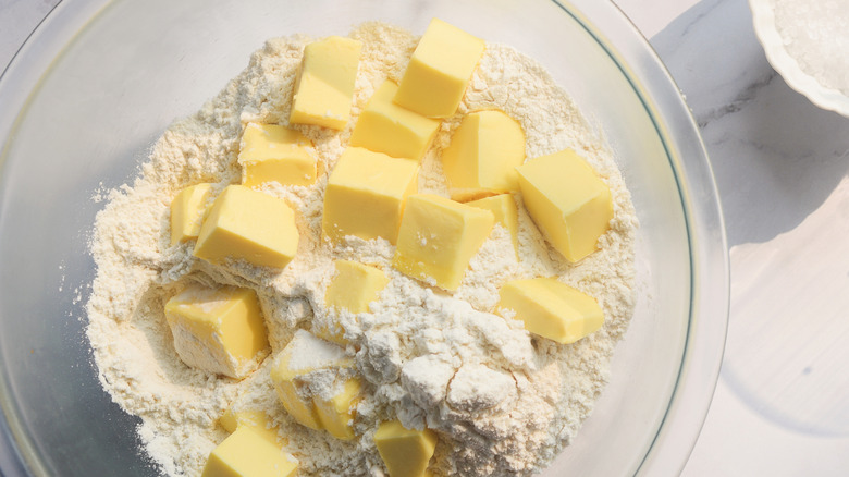 Bowl with cubes of butter in flour