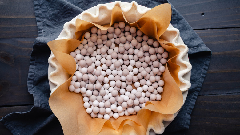 Pie crust with parchment paper and baking beans