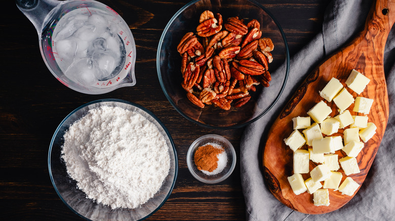 A display of pie ingredients, includeing butter, flour, and pecans