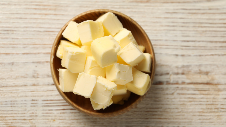 Butter cubes in a bowl on a wooden table