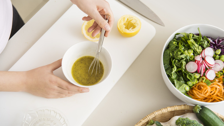 Hands whisking salad dressing