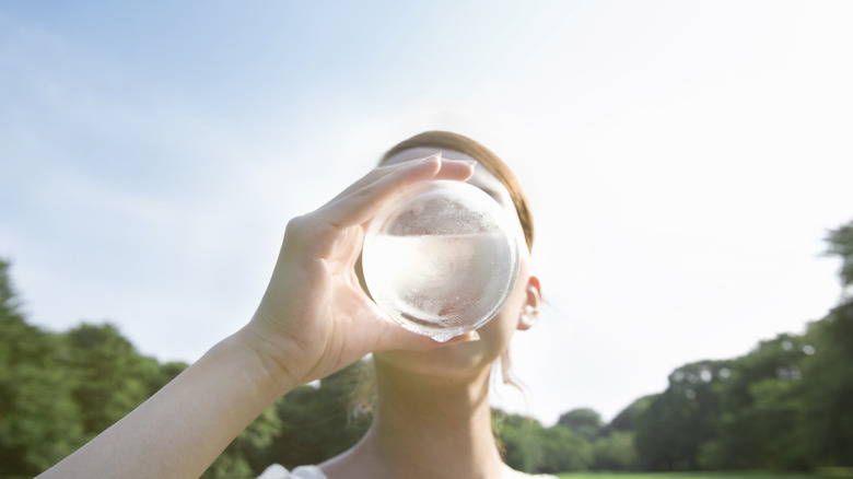 person drinking from water bottle